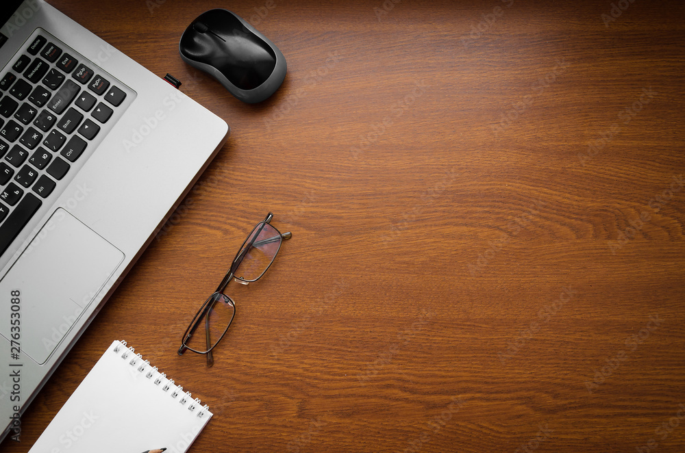 Wood office desk table with laptop, glasses, notebook, pen, smartphone. Top view, copy space Wood office desk table with laptop, glasses, notebook, pen, smartphone. Top view, copy space