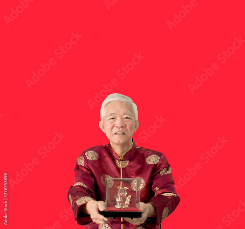 Fototapeta Asian senior man give gold pig sculpture for Chinese new year boar year
