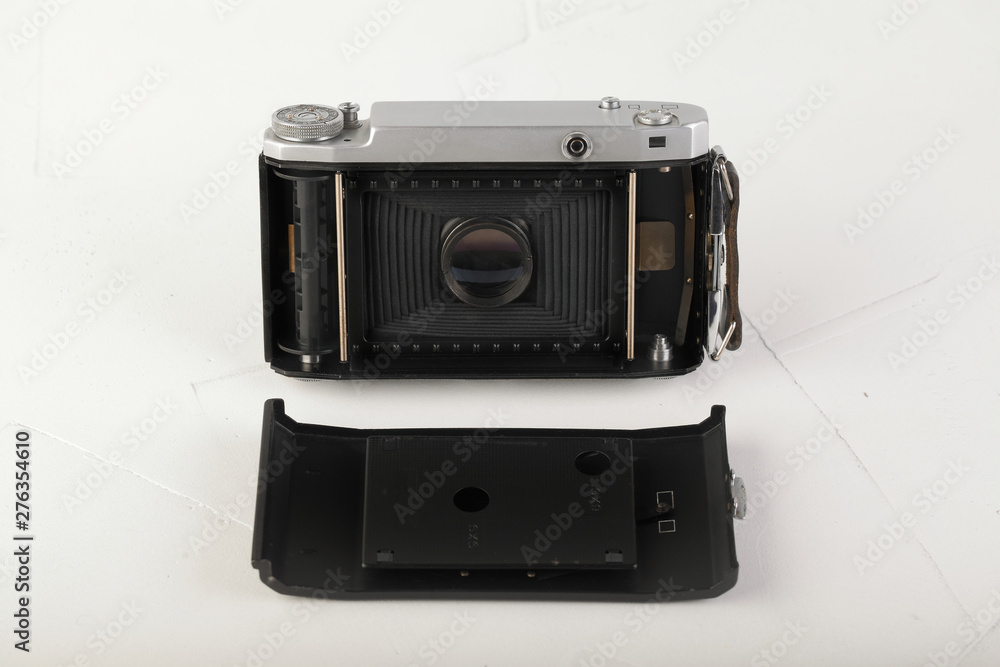 Old medium format rangefinder film camera on white cement background. Old medium format rangefinder film camera on white cement background.