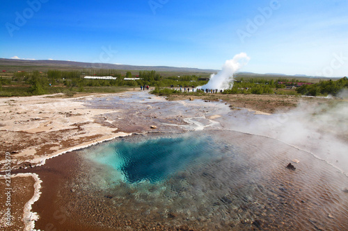 Hot spring et éruption du geyser Strokkur (en arrière plan) en Islande