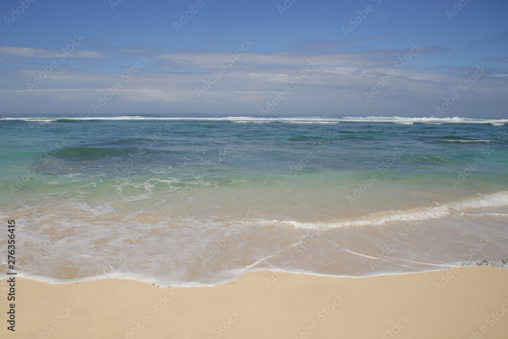 View from a beautiful white sandy beach on the ocean horizon and blue sky	