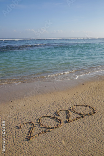 2020 written on the empty sandy beach