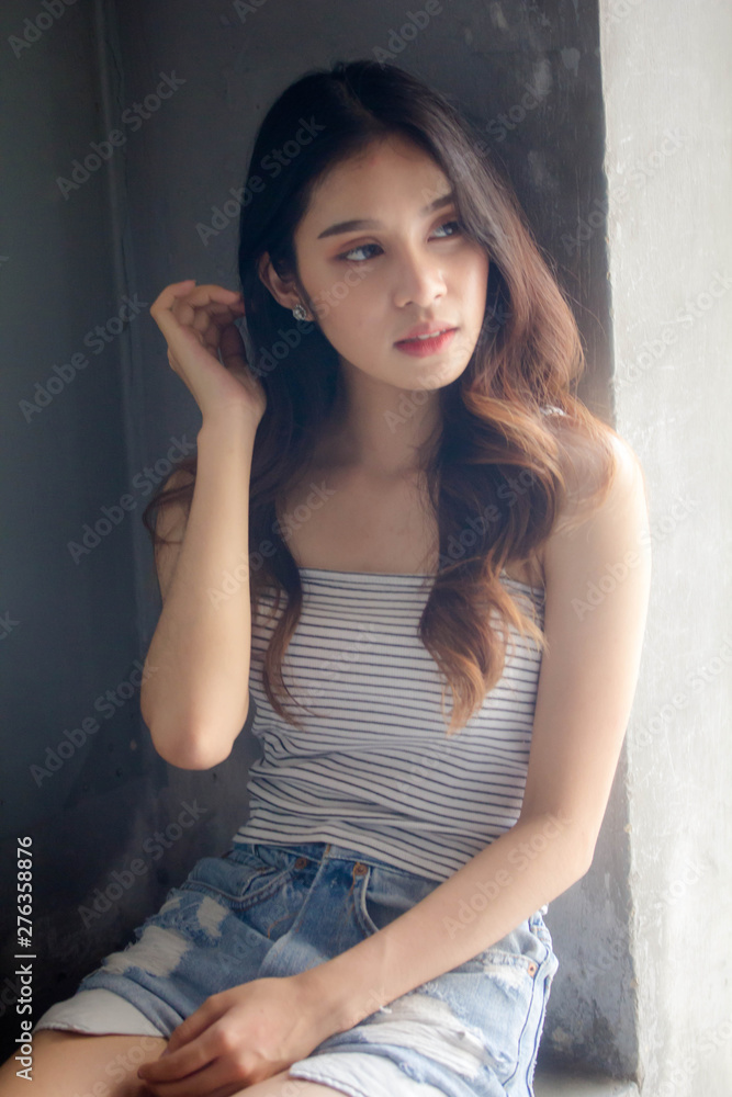 Fototapeta premium Portrait of thai adult beautiful girl White shirt blue jeans relax time