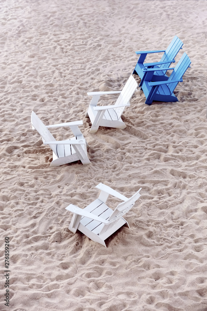 Blue and white plastic deckchairs on the white sands of a beach Blue and white plastic deckchairs on the white sands of a beach