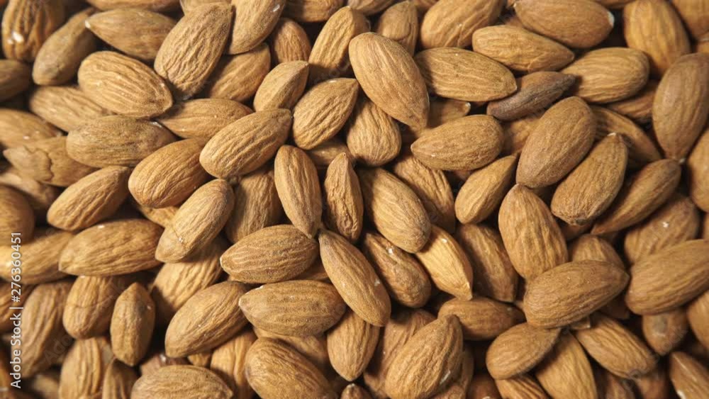 Brown almonds as natural food background or texture. Top down view. Healthy food, good for heart health, high in magnesium mineral Brown almonds as natural food background or texture. Top down view. Healthy food, good for heart health, high in magnesium mineral