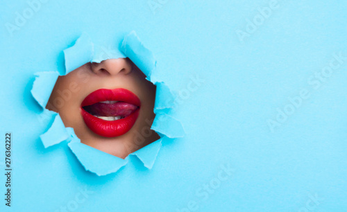 Fototapeta Naklejka Na Ścianę i Meble -  Young Woman Erotically Playing with Tongue in Paper Hole