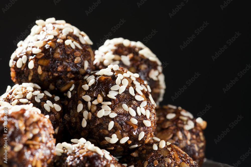 Raw homemade paleo energy balls with rolled oats, nuts, dates and sesame, horizontal, close up. Vegan sweet dessert Raw homemade paleo energy balls with rolled oats, nuts, dates and sesame, horizontal, close up. Vegan sweet dessert