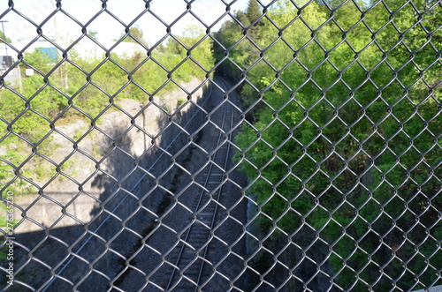metal chain link fence with train tracks below