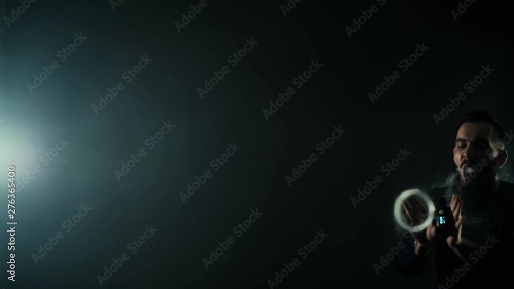 Bearded manly man showing vaping tricks and making vapour jellyfish