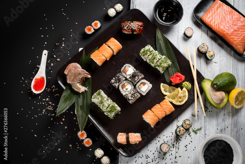 Sushi set with salmon, eel, tuna, avocado, cream cheese Philadelphia, caviar, chuka. Sushi menu. Japanese food on black and white background