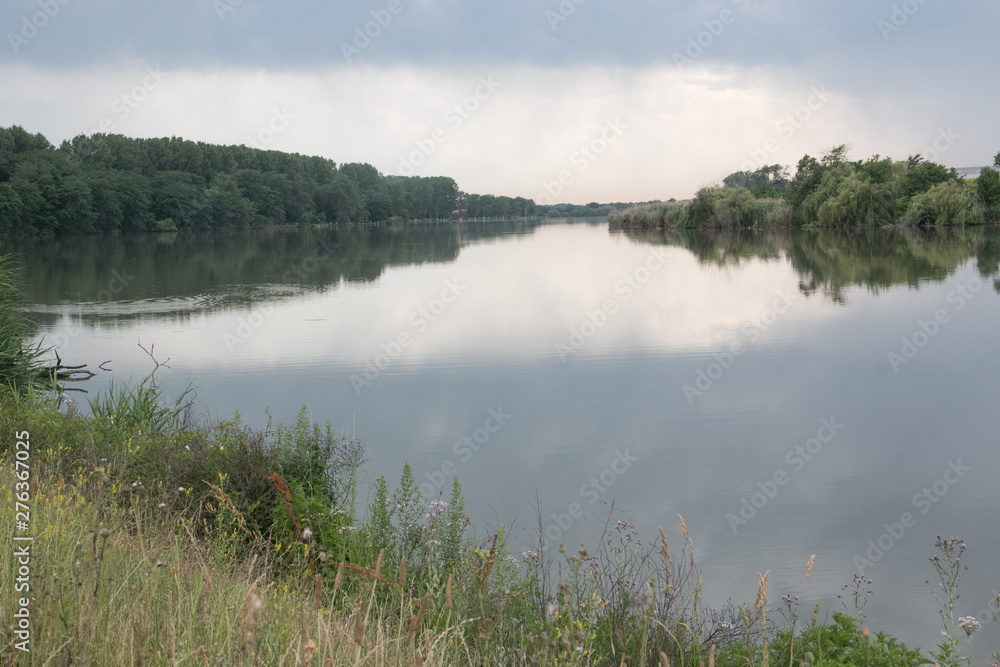 Fototapeta premium Blue sky and green forest reflected in the Kuban river