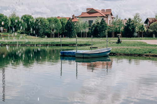 Blue  fishing boat moored to the shore of the lake