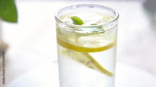 Wallpaper Mural Glass with cold water, with lemon, ice and mint. Rotating video HD Slow motion Torontodigital.ca
