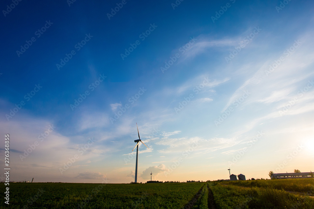 Wind industry in rural area. Turbines in farmlands in evening. Beautiful landscape Wind industry in rural area. Turbines in farmlands in evening. Beautiful landscape