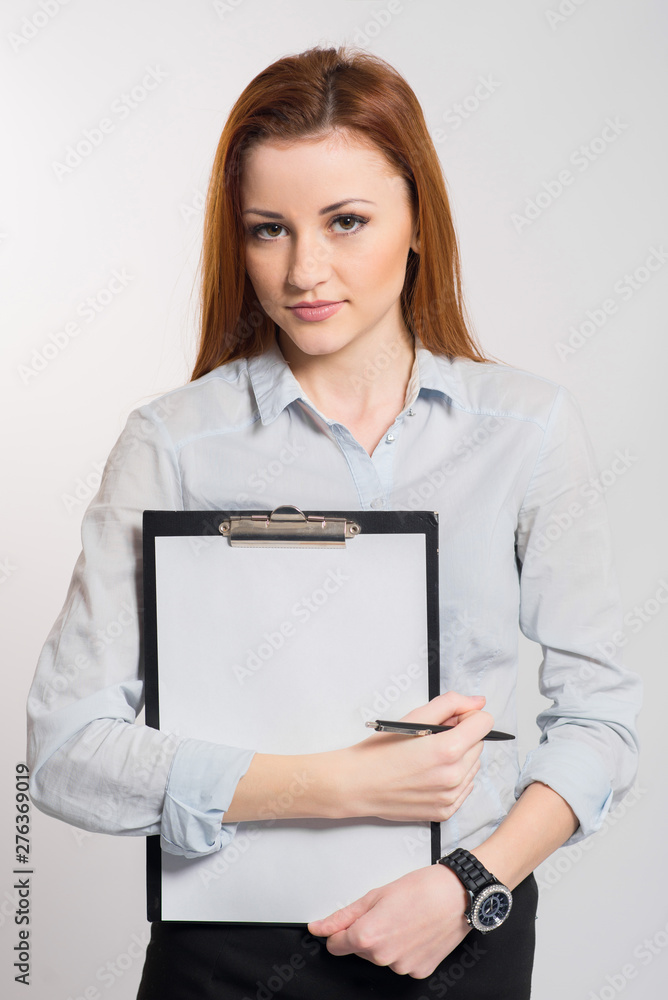 Happy smiling woman in strict clothes and glasses holding a clipboard on grey Happy smiling woman in strict clothes and glasses holding a clipboard on grey