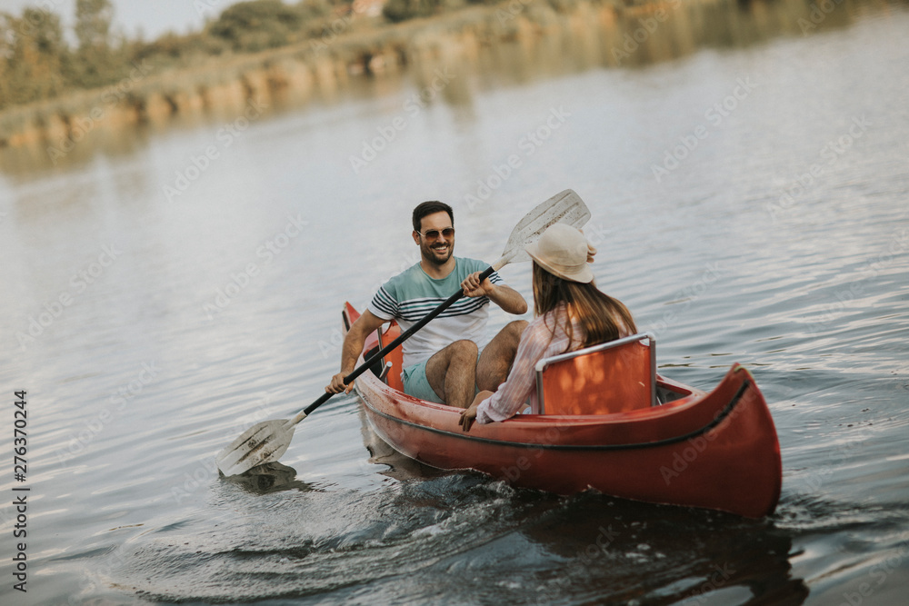 Loving couple rowing on the lake
