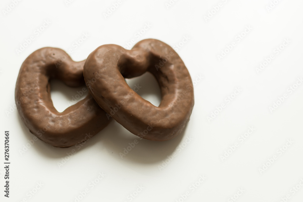 Chocolate glazed gingerbread cookies on white background. Chocolate pastry in a heart shape top view. Copy space. Chocolate glazed gingerbread cookies on white background. Chocolate pastry in a heart shape top view. Copy space.