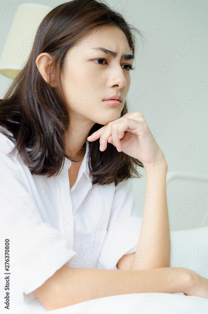 Asian women are headache severely.Lady wake up in the morning with migraine. Insomnia results in headaches when awakened.Young girl sitting on a stressed bed. Asian women are headache severely.Lady wake up in the morning with migraine. Insomnia results in headaches when awakened.Young girl sitting on a stressed bed.