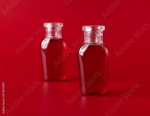 Shampoo and shower gel against red background