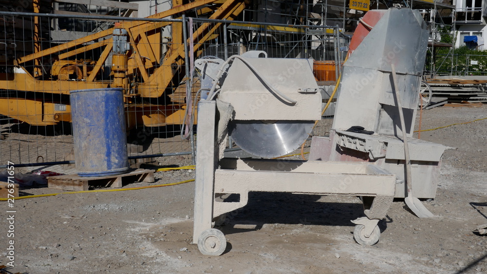 Stone circular saw and various work materials on a construction site.