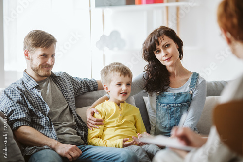 Caring parents and misbehaving boy during therapy session with counselor photo