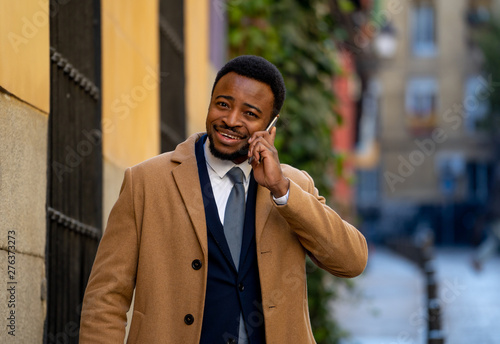 Smiling attractive stylish mature man using smart phone in urban outdoors city