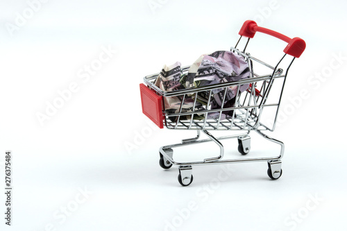 A grocery cart filled with crumpled dollars. isolate on white background © Alex
