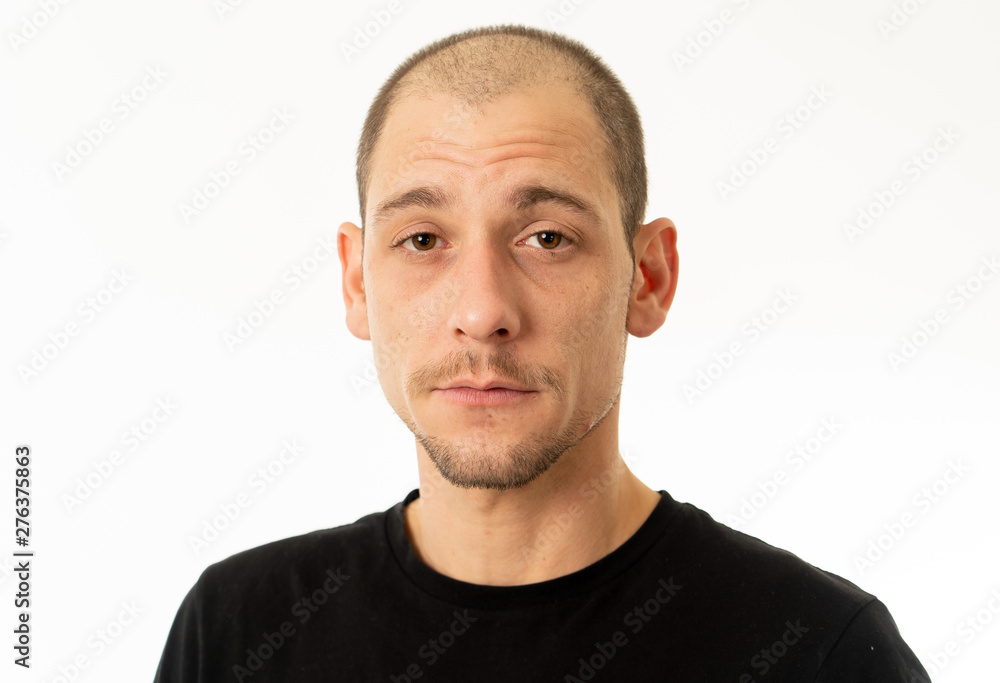 Human expressions and emotions. Portrait of young attractive man with a serious neutral face Human expressions and emotions. Portrait of young attractive man with a serious neutral face