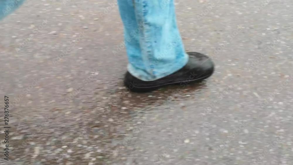 Legs of a man walking along an asphalt road Legs of a man walking along an asphalt road