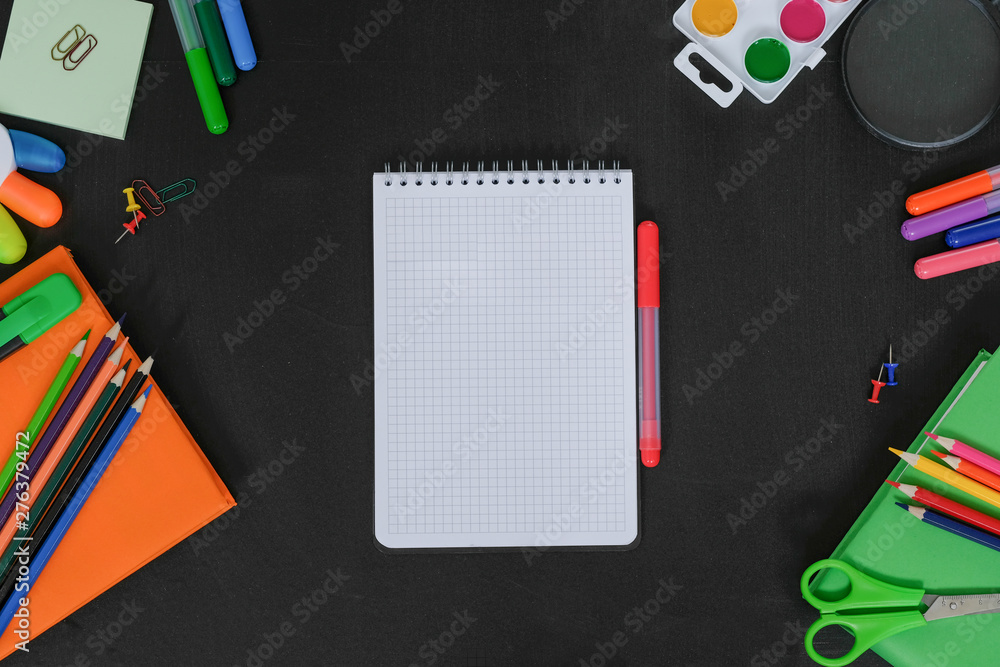 School supplies on black board background. Back to school concept. Space for text. View from above School supplies on black board background. Back to school concept. Space for text. View from above