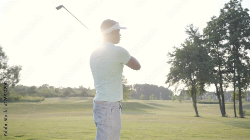 Portrait handsome successful middle eastern golfer swinging and hitting golf ball on beautiful course. Confident man golfing in beautiful sunny summer weather standing in the sunshine. Portrait handsome successful middle eastern golfer swinging and hitting golf ball on beautiful course. Confident man golfing in beautiful sunny summer weather standing in the sunshine.