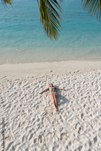 Paradise on earth - the girl lies on a white beach on a paradise island.