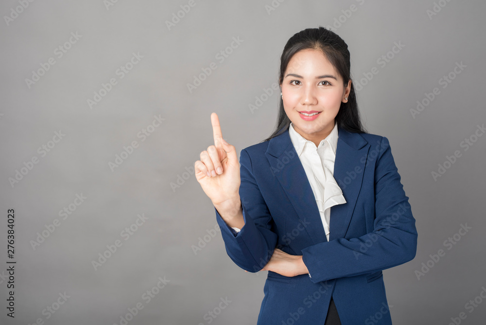 Portrait of smart  business woman in blue suit on grey background, studio shot