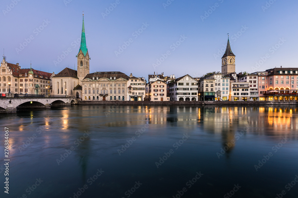 Beautiful view of Fraumunster Church and old town zurich by limmat river before sunrise