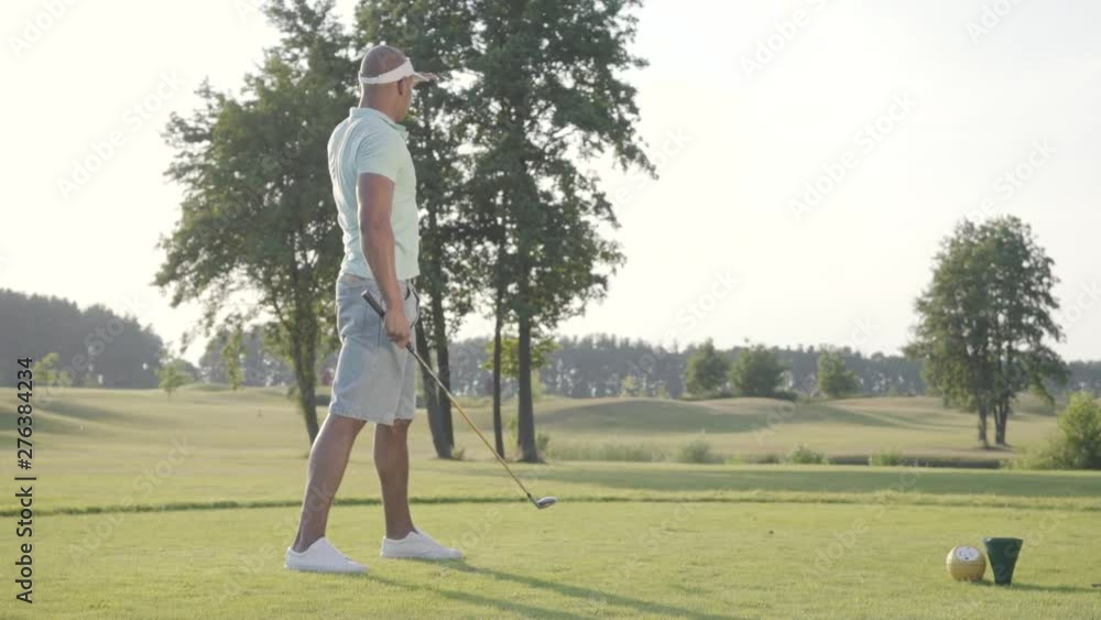 Portrait handsome successful middle eastern golfer swinging and hitting golf ball on beautiful course. Confident man golfing in beautiful sunny summer weather standing in the sunshine. Portrait handsome successful middle eastern golfer swinging and hitting golf ball on beautiful course. Confident man golfing in beautiful sunny summer weather standing in the sunshine.