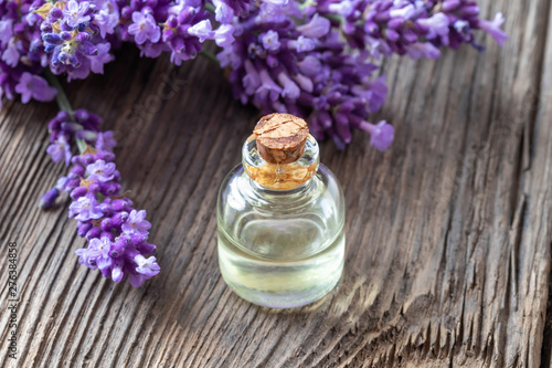 A bottle of lavender essential oil with fresh lavender