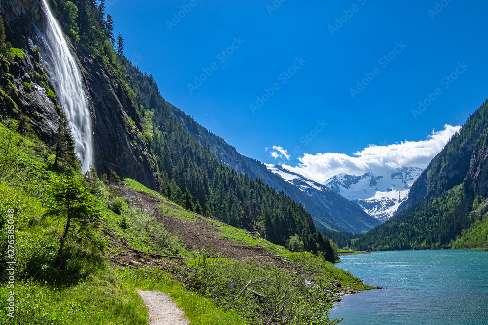Alps mountains with blue lake and waterfall. Photo taked at Stillup Lake, Austria, Tyrol Region