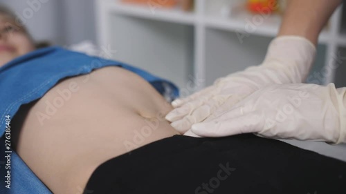 The doctor palpated the abdomen of a young patient in a medical office., close-up.