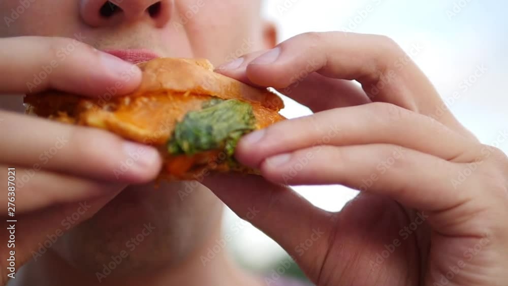 Man eating a hamburger. close-up shot. Fast food eats