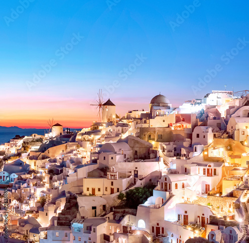 Oia at sunset. Beautiful view of the village of Oia, Santorini, Greece, Aegean sea, Europe. Classic white Greek architecture, houses, churches, windmills. Travel concept, popular place