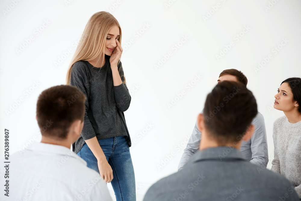 Young woman talking about her problems during group therapy Young woman talking about her problems during group therapy