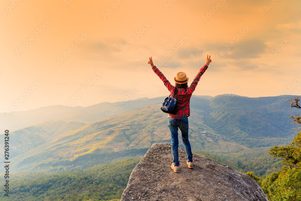 Happy standing on a rock with raised hands and looking at the valley below in Phu Lom Lo mountain, Loei, Thailand. Happy standing on a rock with raised hands and looking at the valley below in Phu Lom Lo mountain, Loei, Thailand.