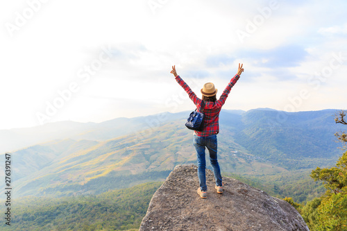 Fototapeta Naklejka Na Ścianę i Meble -  Happy guys standing on a rock with raised hands and looking at the valley below in Phu Lom Lo mountain, Loei, Thailand.