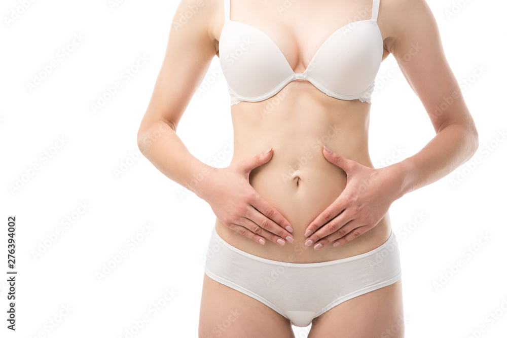 partial view of young woman in underwear touching belly isolated on white