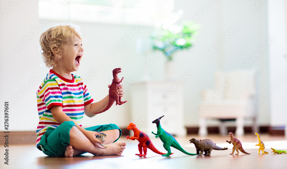 Child playing with toy dinosaurs. Kids toys. - obrazy, fototapety, plakaty 