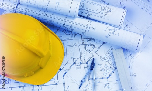 Foto Blueprints construction and a yellow hardhat with a compass