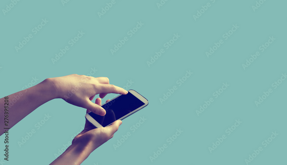 Person holding a white smartphone on a solid colored background - obrazy, fototapety, plakaty 