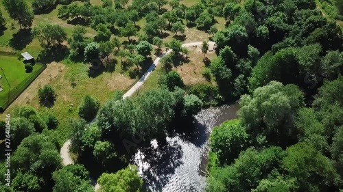 Aerial, tilt up, drone shot, over Vilnele river, revealing the nature near the Puckoriu atodanga, sunny summer day, in Pavilniai regional park, Belmontas, near Vilnius, in Lithuania photo