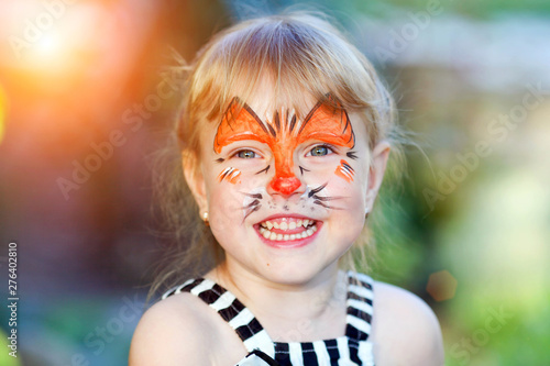 Portrait of funny girl with face painting on blurred background