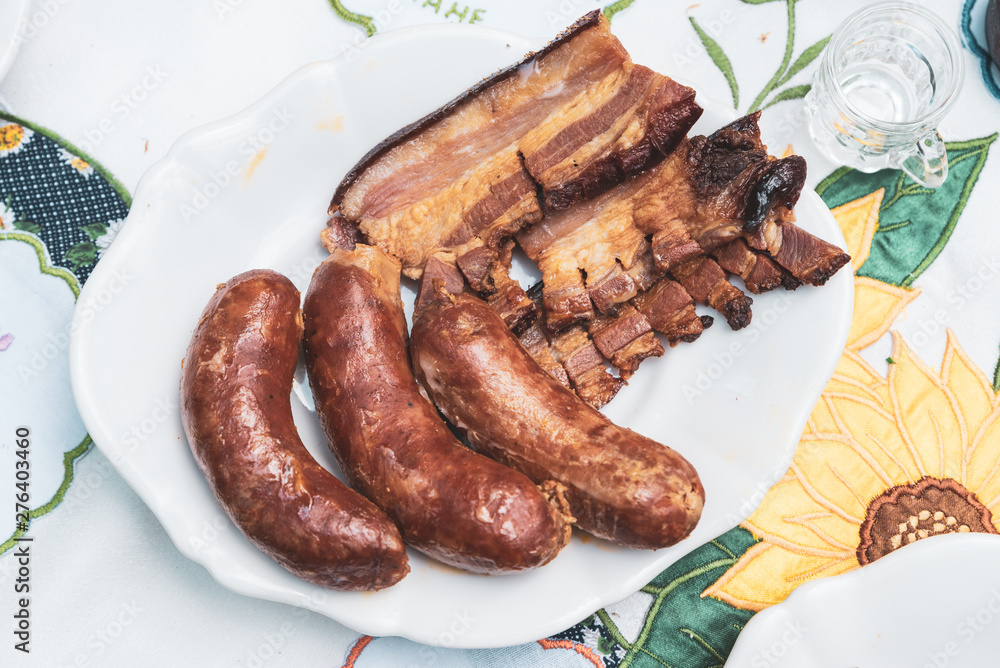 roasted bacon and sausages served on the table roasted bacon and sausages served on the table